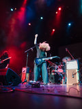 Canadian band The Needful, Glenn on stage with raised fist, surrounded by band equipment under colorful lights